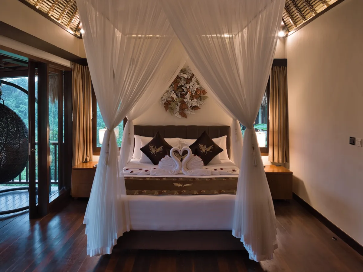Jungle View Villa canopy bedroom with hanging chair and private balcony overlooking the rainforest in Ubud, Bali