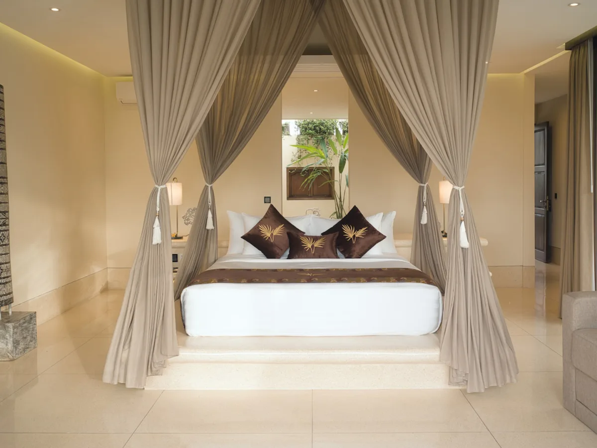 Panoramic Corner Jacuzzi Royal Suite bedroom with living area, private balcony, and tropical views in Ubud, Bali