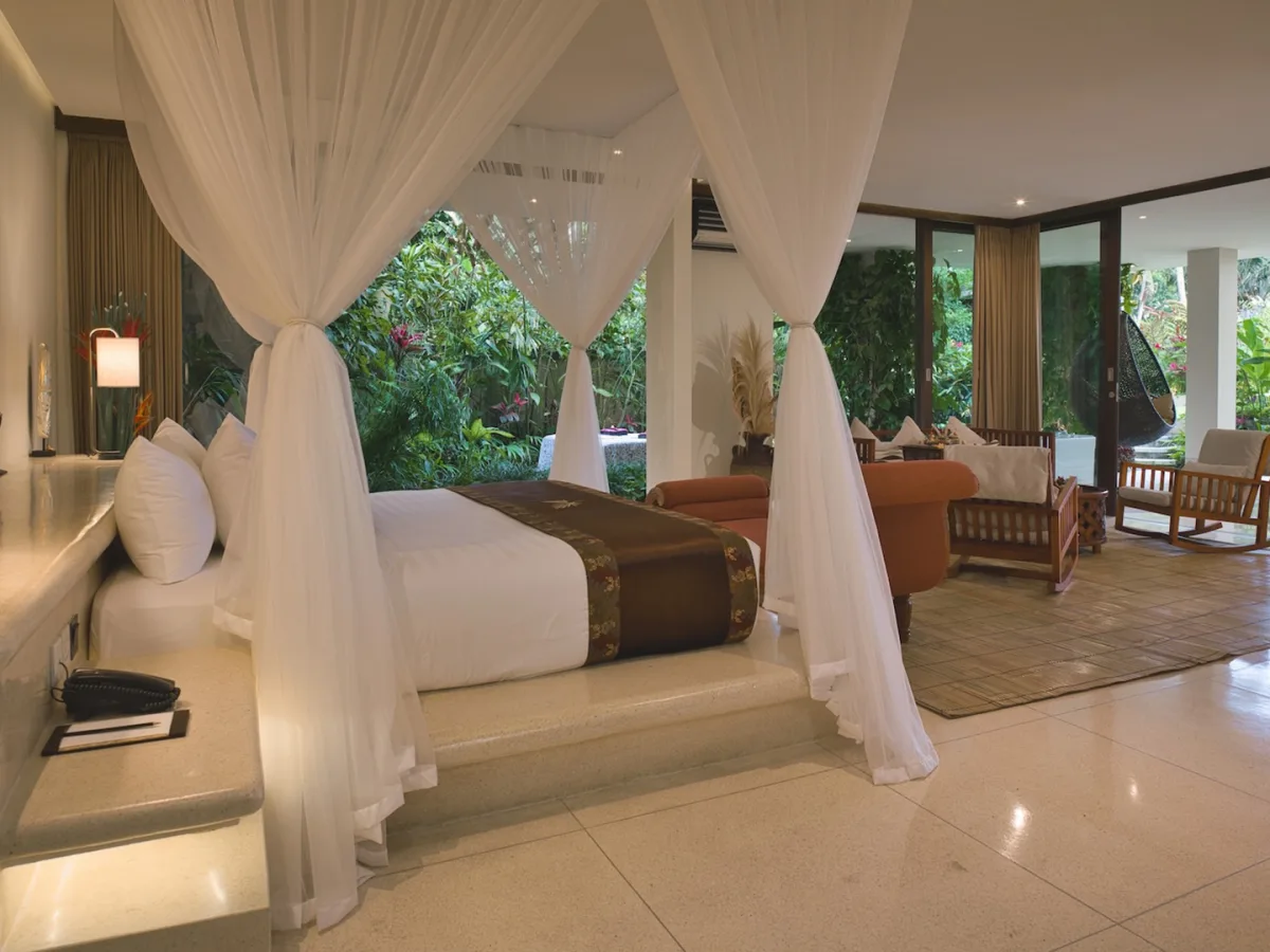 Presidential Royal Suite canopy bedroom with spacious living room and private garden views in Ubud, Bali