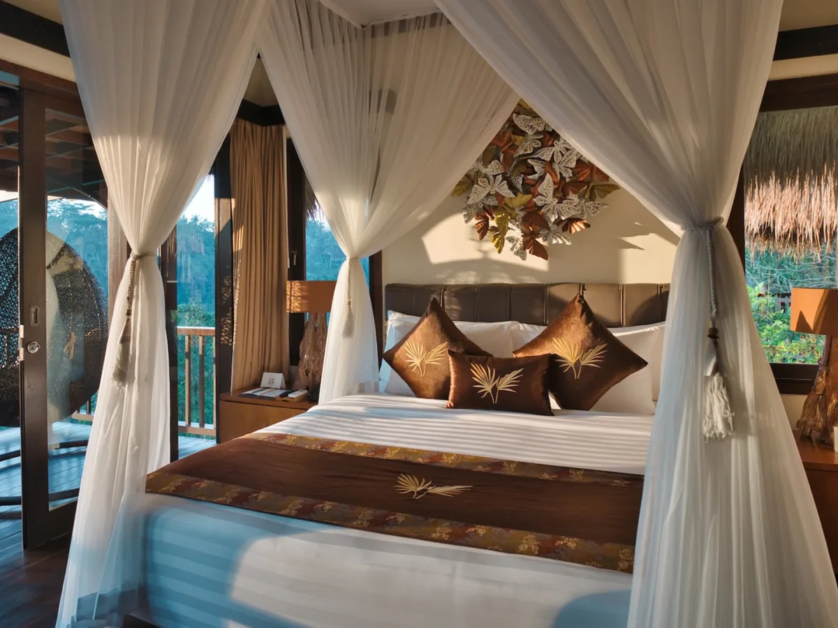 Sunrise View Villa bedroom with canopy bed, private balcony, and rainforest views in Ubud, Bali