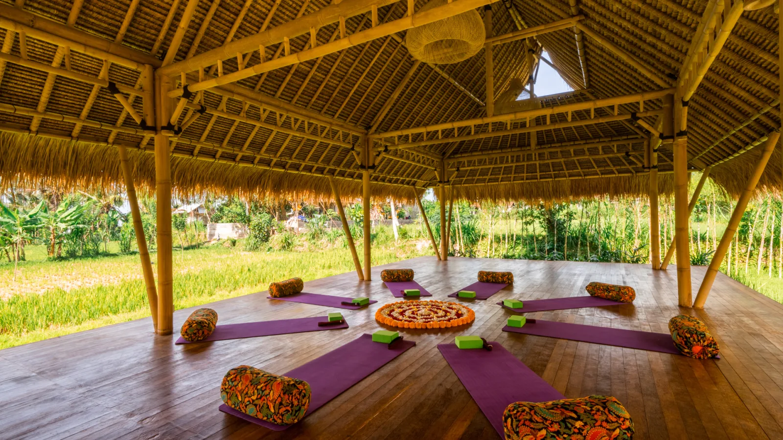 Yoga mats inside Djiwa Shala pavilion overlooking rice fields at Nandini Jungle by Hanging Gardens