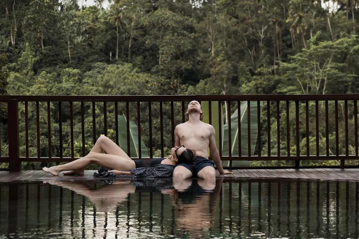 Couple relaxing beside a jungle-view pool during a wellness retreat day pass at Nandini Jungle by Hanging Gardens.
