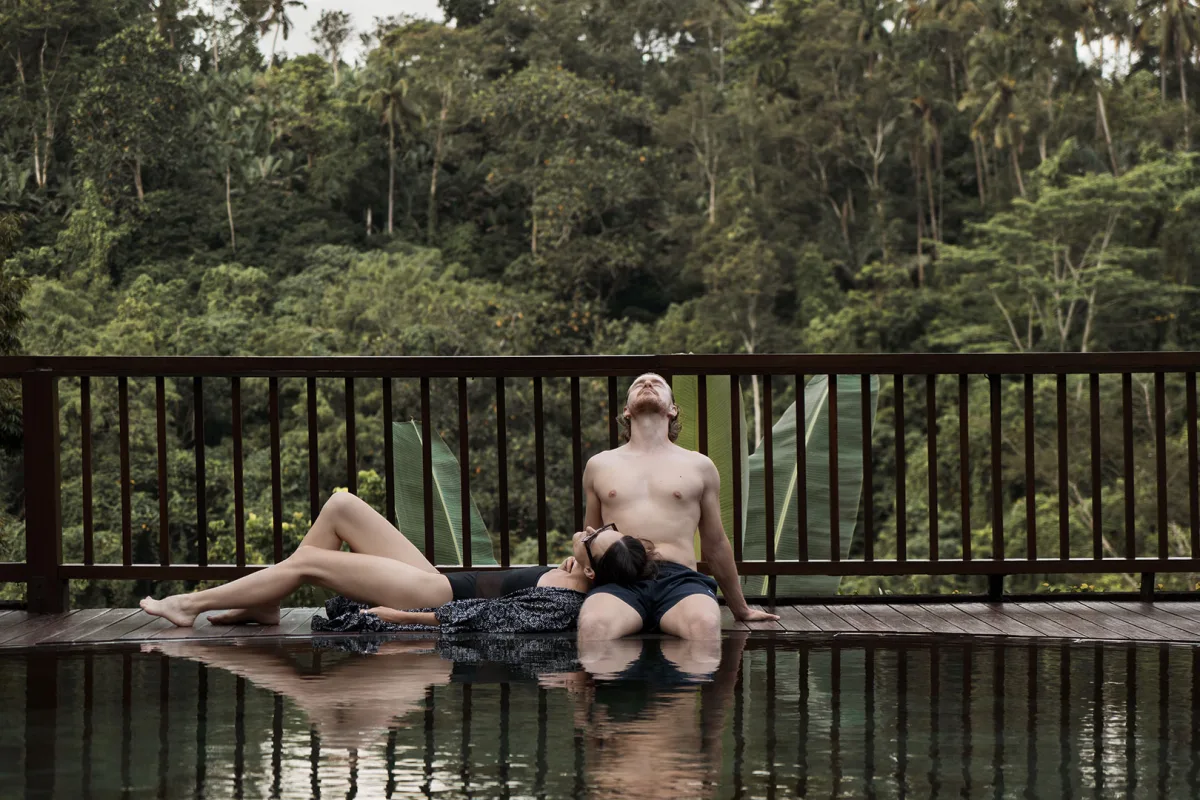 Guest relaxing by the infinity pool overlooking the lush tropical jungle at Nandini Jungle by Hanging Gardens in Ubud, Bali.