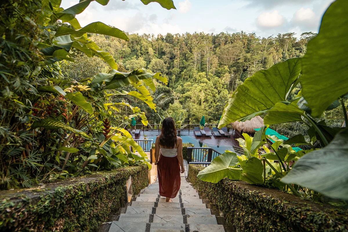 Guest walking through the tropical jungle surroundings at Nandini Jungle by Hanging Gardens in Ubud, Bali