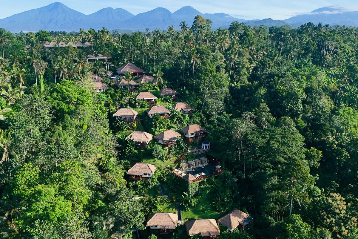 Aerial view of Nandini Jungle by Hanging Gardens, featuring luxury villas surrounded by lush tropical rainforest and scenic mountains in Ubud, Bali.