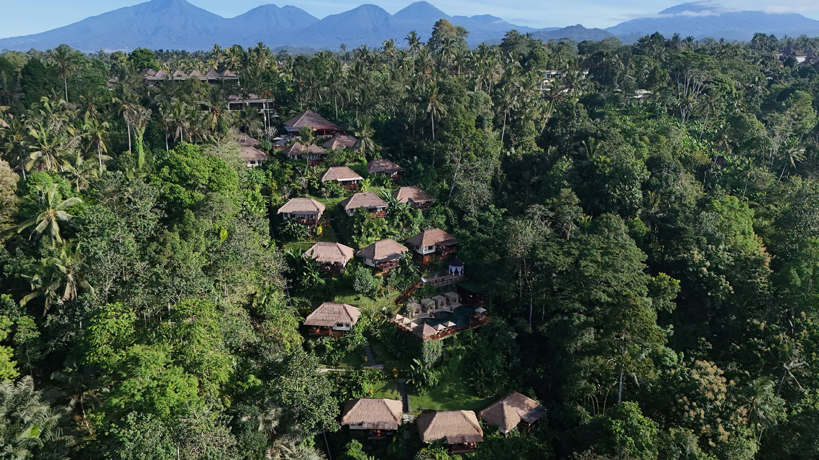 Woman enjoying panoramic jungle views from a private balcony at Nandini Jungle by Hanging Gardens in Ubud