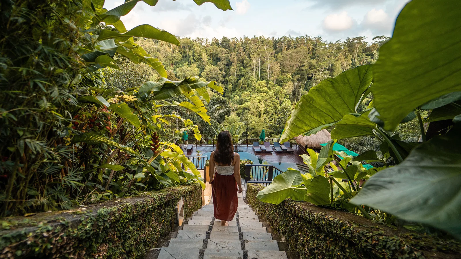 Guest walking through the tropical jungle surroundings at Nandini Jungle by Hanging Gardens in Ubud, Bali